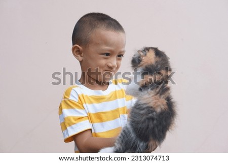 Asian boy smiling happily with his pet cat