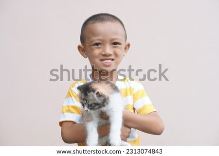 Asian boy smiling happily with his pet cat
