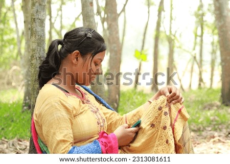 The girl is sitting under a tree