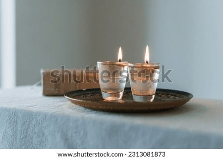 On the table are two candles lit on shabbat and a siddur (religious jewish prayer book). Jewish holidays and traditions (249) Royalty-Free Stock Photo #2313081873