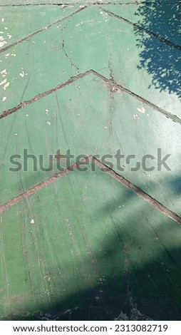 The green colored concrete floor forming directional markers in the garden pathway