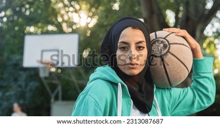 Close Up of Beautiful Muslim Young Woman Holding a Basket Ball While Looking at the Camera. Female Athlete in a Hijab Defying Stereotypes and Following her Dream of Going Professional