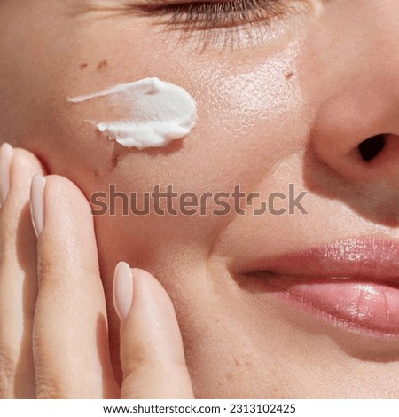 Hydration. Cream smear. Beuaty close up portrait of young woman with a healthy glowing skin is applying a skincare product.  Royalty-Free Stock Photo #2313102425