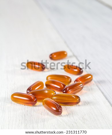 Tablets of vitamin E. On a white wooden texture