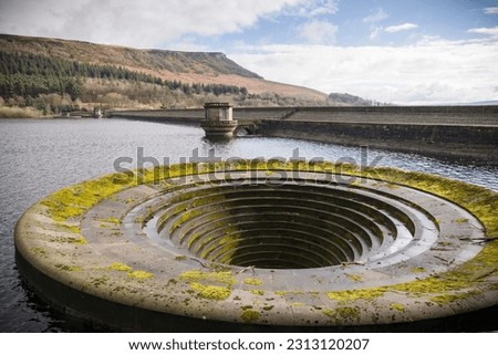 Ladybower reservoir dam wall and bellmouth spillway in winter, Peak District, UK Royalty-Free Stock Photo #2313120207