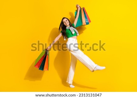 Full body photo of pretty positive lady hold mall bags super proposition clothes ad isolated on yellow color background