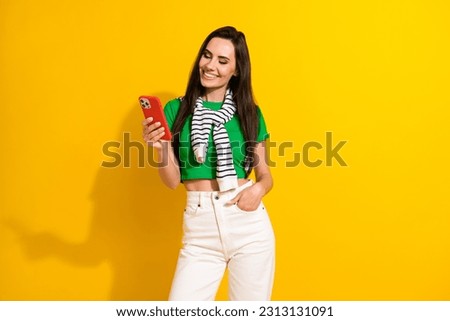 Photo of cute shiny girl dressed green t-shirt texting apple samsung iphone gadget isolated yellow color background