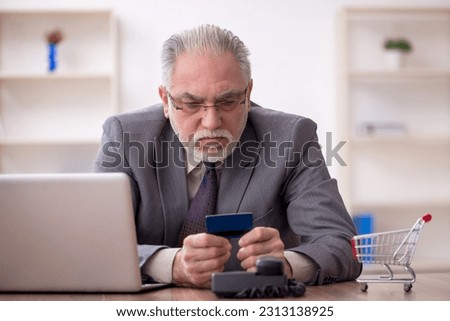 Old male employee in e-commerce concept Royalty-Free Stock Photo #2313138925