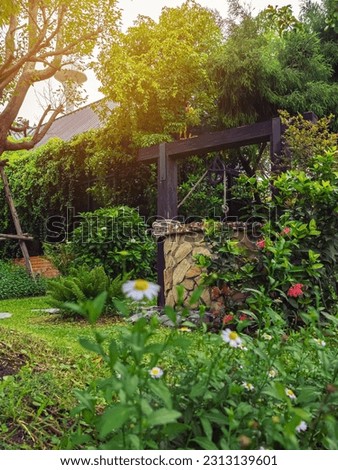 Beautiful artesian well made by stones and wheel pulley with metal bucket and rope in peaceful garden atmosphere. Retro stone water well in rural area. Beautiful garden decoration with antique items. Royalty-Free Stock Photo #2313139601