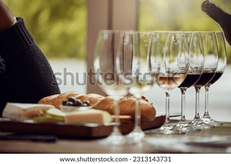 Wine tasting, cheese platter and winery restaurant with alcohol and glass for customer. Waiter, drink and sommelier with bottle for wines and food pairing in a fine dining and luxury experience Royalty-Free Stock Photo #2313143731