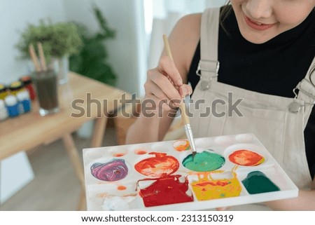 Professional female artist girl use paintbrush in abstract art for create masterpiece. painter paint with watercolors or oil in studio house. beautiful woman enjoy painting as hobby. work recreation