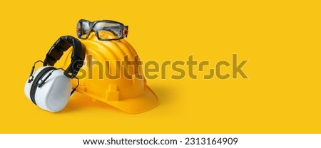 Safety helmet, ear muffs and goggles: personal protective equipment and workplace safety concept Royalty-Free Stock Photo #2313164909