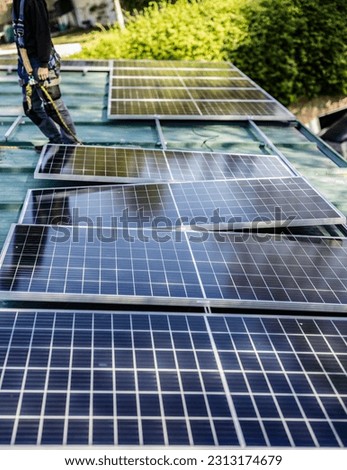 Asian technician checks the maintenance of the solar panels on the roof.
