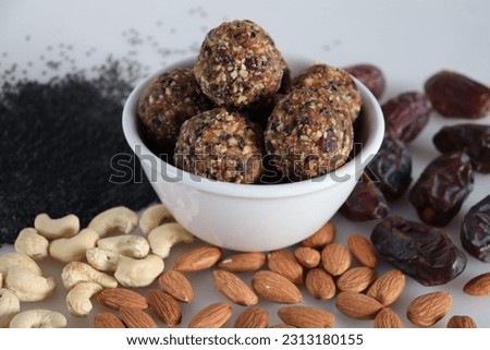 Sugar free dates and nuts ladoo. Healthy and protein rich energy balls in the shape of ladoos made from dates, almonds, cashew nuts and sesame seeds without adding any sugar. Shot on white background Royalty-Free Stock Photo #2313180155