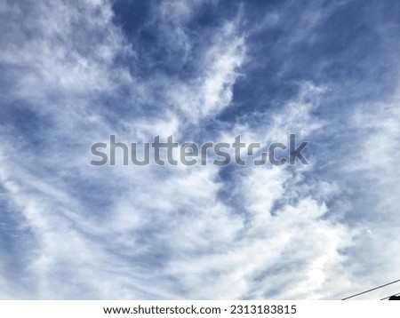The image described is a beautiful blue sky landscape with white clouds that look very soft and layered. With the horizon line dividing the sky and the land, this image looks very calming and soothing