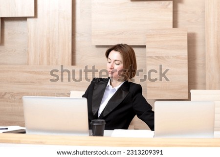Serious business woman in black suit working in modern office	