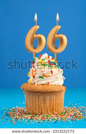 Birthday cake with candle number 66 - Blue background Royalty-Free Stock Photo #2313222173