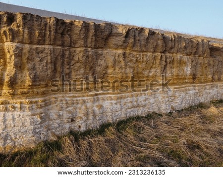yellow and brown dirt texture background, with small rocks and dust. Excavation dirt texture exposed. High quality photo. a rock landslide, all layers of soil and stone are visible. excavations.