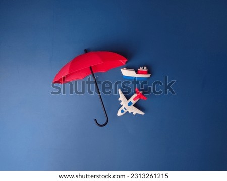 Top view red umbrella covered ship and airplane on a blue background