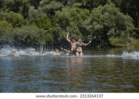 Young people cooling off in the river on hot summer vacation, Group picture photo of friends, guys and girls, splashing water