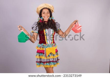Black, Brazilian woman, wearing June party clothes, fraternization in the name of São João, Arraial. Screaming while holding flags.