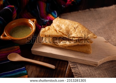 Golden quesadillas. Fried quesadillas made with corn tortillas, they can be filled with any dish or ingredient, such as meat, potato or fish such as marlin or tuna, popular during the Lenten season. Royalty-Free Stock Photo #2313281305