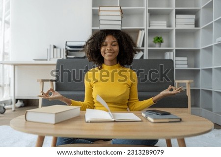 Young African American woman learning from a book. learning materials University study projects, attend online learning meetings, watch video lessons on the Internet, write notes.