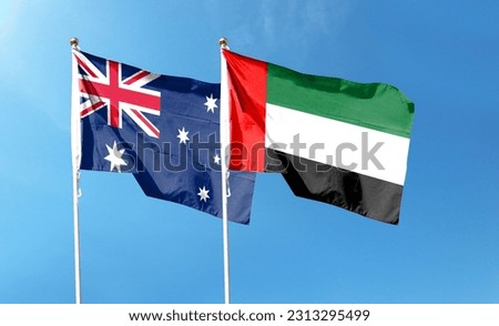 Australian flag and UAE flag on cloudy sky. waving in the sky