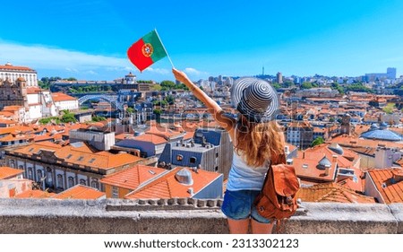 Porto travel destination- Woman with portuguese flag enjoying panoramic view of city landscape of Oporto- Portugal Royalty-Free Stock Photo #2313302123