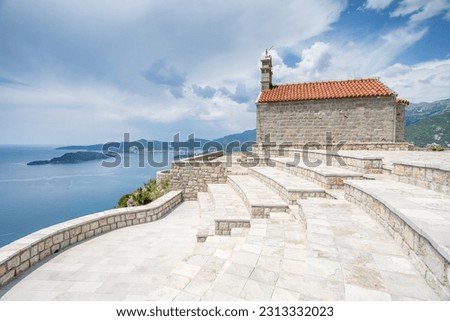 St Sava Church pictured high up on a mountain overlooking Sveti Stefan seen in front of the Budva Riverira in May 2023.