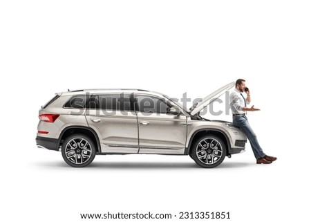 Man with a broken car calling road assistance isolated on white background Royalty-Free Stock Photo #2313351851