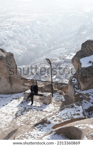 portrait of relaxed man sitting and enjoying the view of cappadocia in winter cover with snow