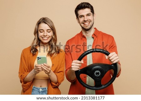 Young fearful couple two friends family man woman wear casual clothes looking camera hold head steering wheel driving car together isolated on pastel plain light beige color background studio portrait