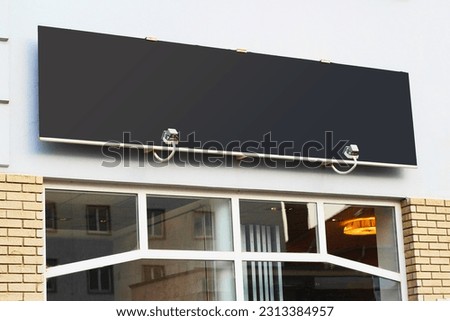 Large black billboard banner on a storefront mockup. Blank white restaurant or shop sign mock up template.