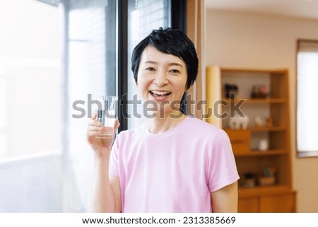 Mature Japanese woman with a glass of water