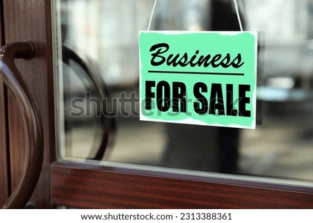 Turquoise sign with Business For Sale hanging on glass door