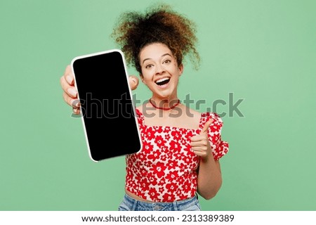Young happy woman she wear casual clothes red blouse hold in hand use close up mobile cell phone with blank screen workspace area show thumb up isolated on plain pastel light green color background