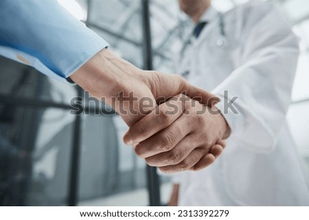 two businessmen shaking hands during a meeting in a modern office.