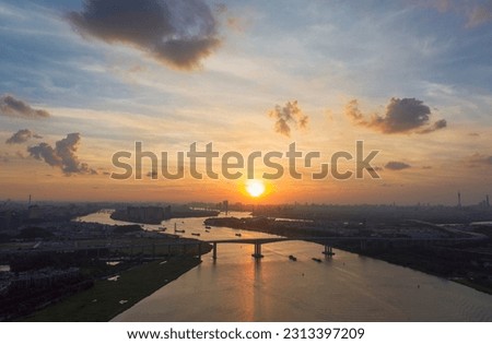 The sunset and dusk of the Pearl River in Guangzhou, the sun, the bridge and the river constitute a beautiful picture