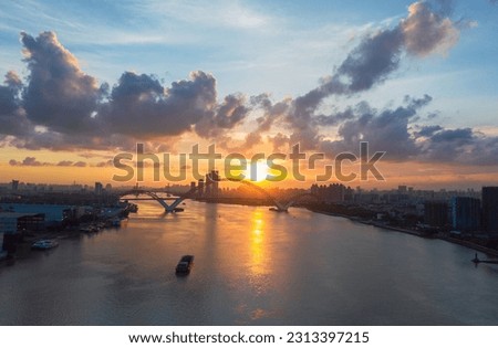 The sunset and dusk of the Pearl River in Guangzhou, the sun, the bridge and the river constitute a beautiful picture