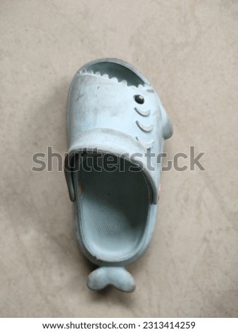 blue children's sandals with a shark shape looks very dirty