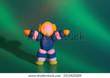 A toy astronaut on a green background. Space and science.