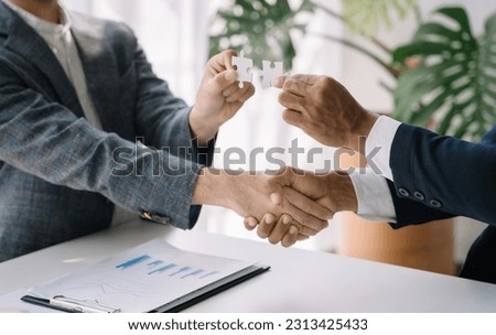 Business team work holding two jigsaw connecting couple puzzle piece for matching to goals target, success and start up new project in office, businessman concept. Royalty-Free Stock Photo #2313425433