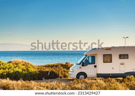 Camper, recreational vehicle on sea coast in Spain. Camping on nature beach. Holidays and traveling in motor home. Royalty-Free Stock Photo #2313429427