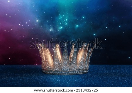 low key image of beautiful queen or king crown over glitter table. fantasy medieval period Royalty-Free Stock Photo #2313432725