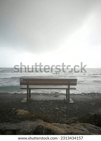 Isolated bench on the Tuscan waterfront with rough seas in front