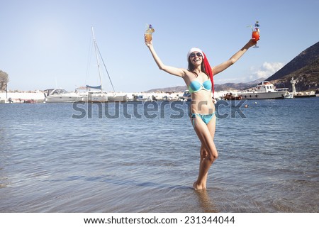 Christmas holiday time: Woman in santa claus hat holding alcoholic cocktails during 