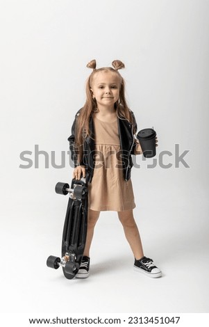 Stylish little girl child with skateboard over white background, Space for advertising