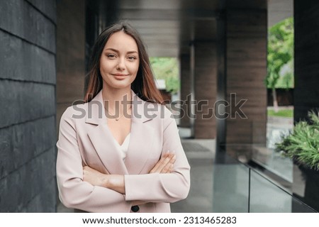 Portrait of a successful business woman with folded hands on the background of an office building. Woman business consultant analyst. copy space Royalty-Free Stock Photo #2313465283