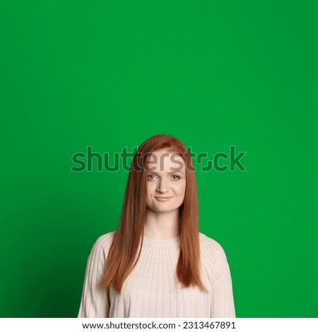 Chroma key compositing. Pretty young woman with red hair against green screen